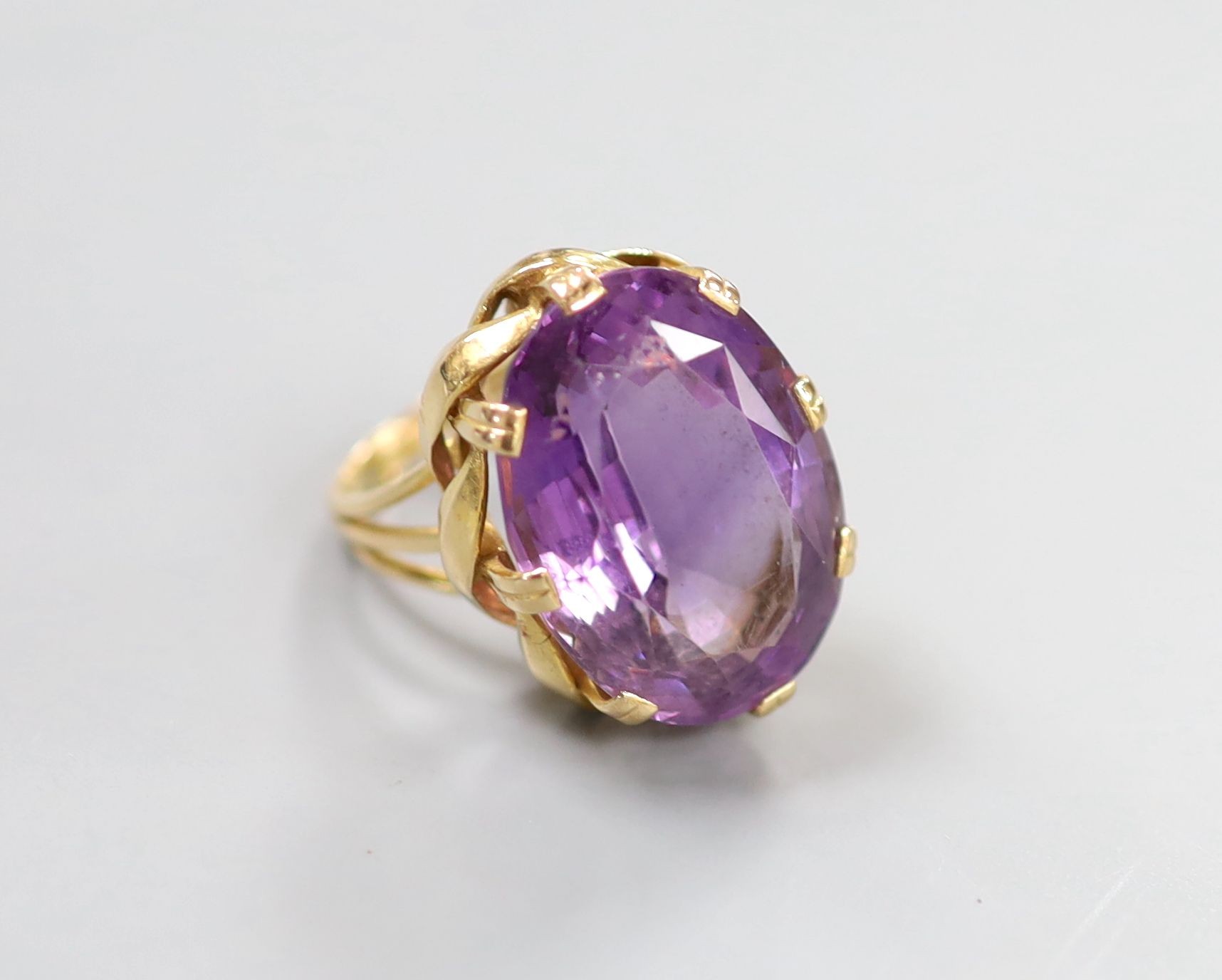 A yellow metal and oval cut amethyst set dress ring, size L, gross weight 11.5 grams.